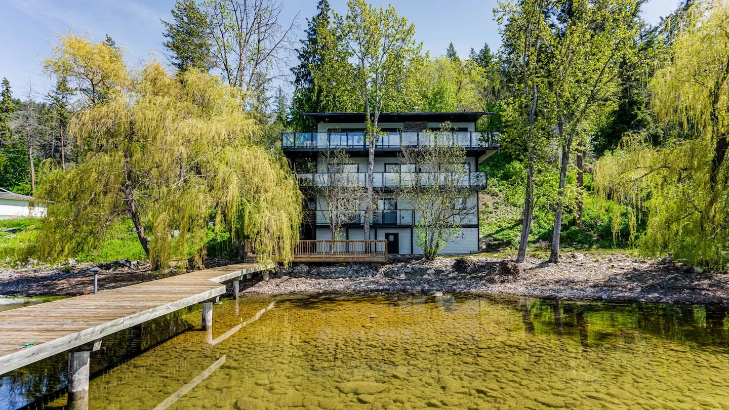 Modern lakefront house with dock and willow trees