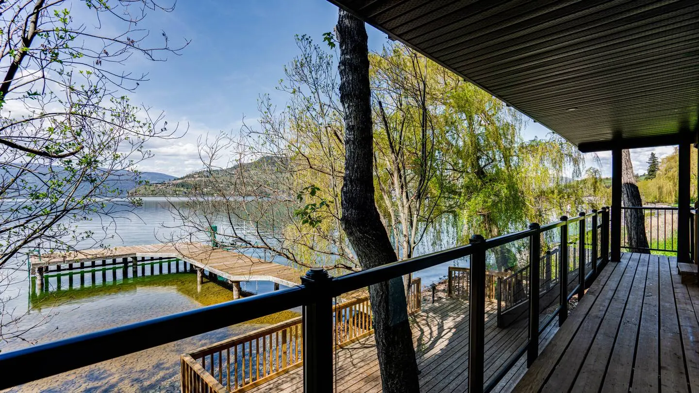 Deck overlooking the dock and lake through willow trees