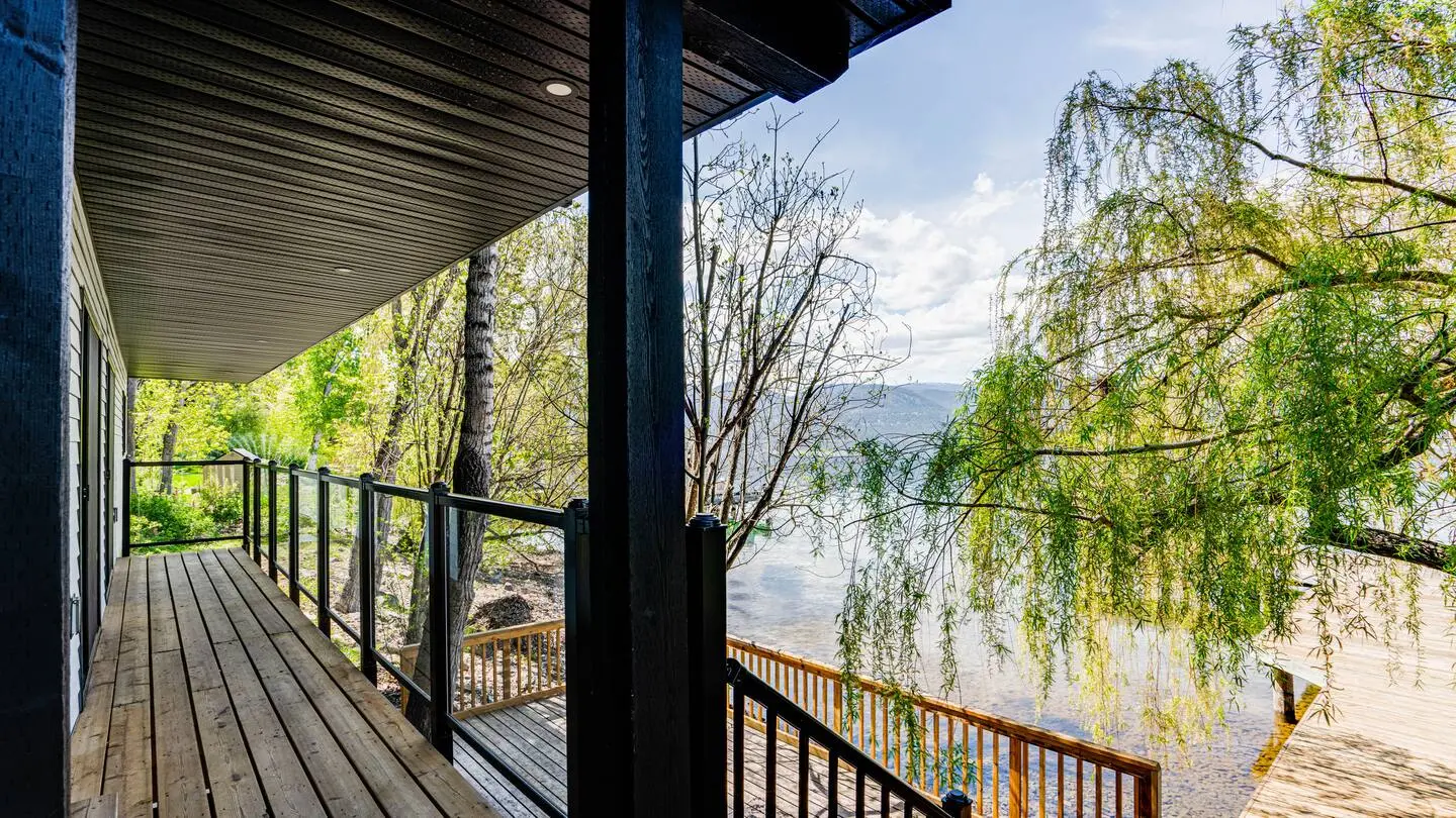 Balcony with a view of the lake through willow trees