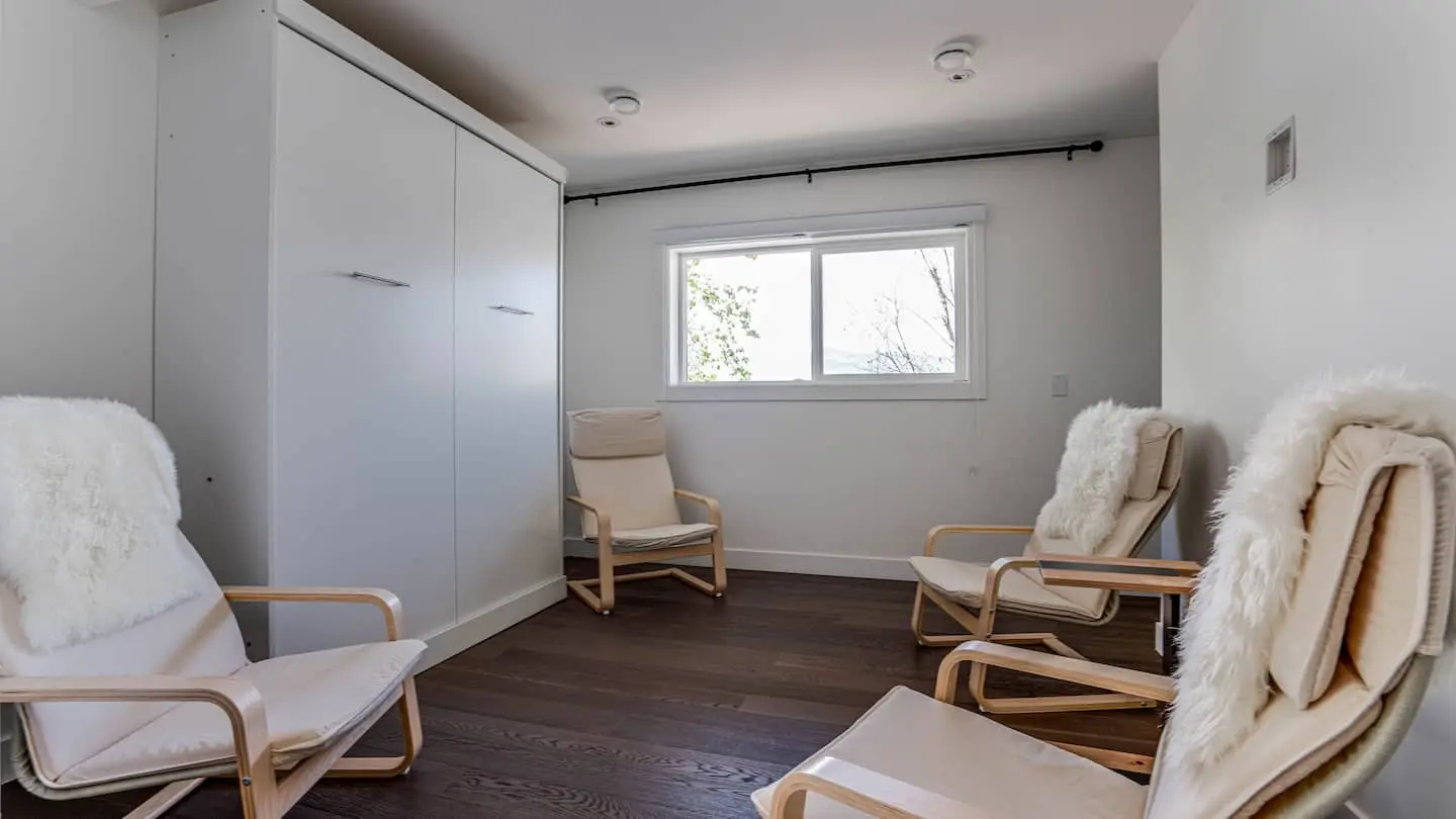 Room with wall bed and lounge chairs